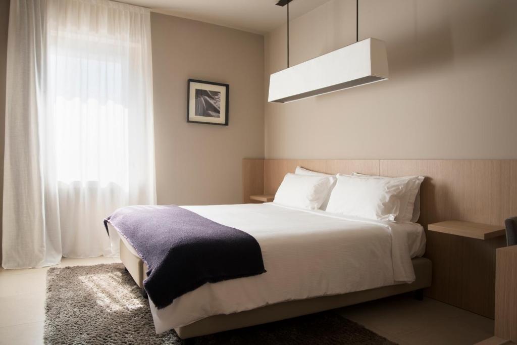 a bedroom with a large white bed and a window at Albergo Nicolin in Lecco