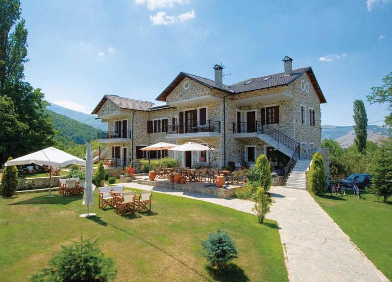 a large house with a yard with tables and chairs at Villa Kastanodasos in Emporio