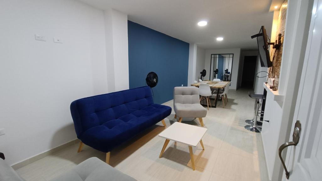 a living room with a blue couch and a table at Hermoso y amplio apartamento con garaje en San Gil in San Gil