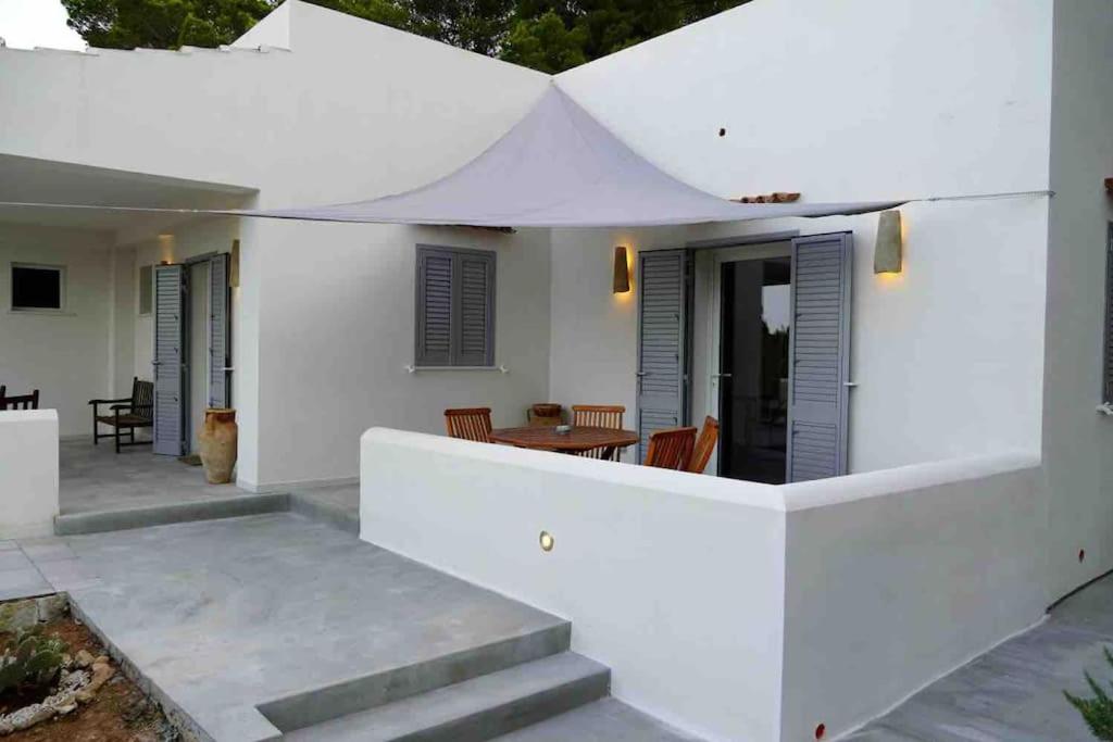 a white house with a patio with a table and chairs at Dimora delle Tonnare in Favignana