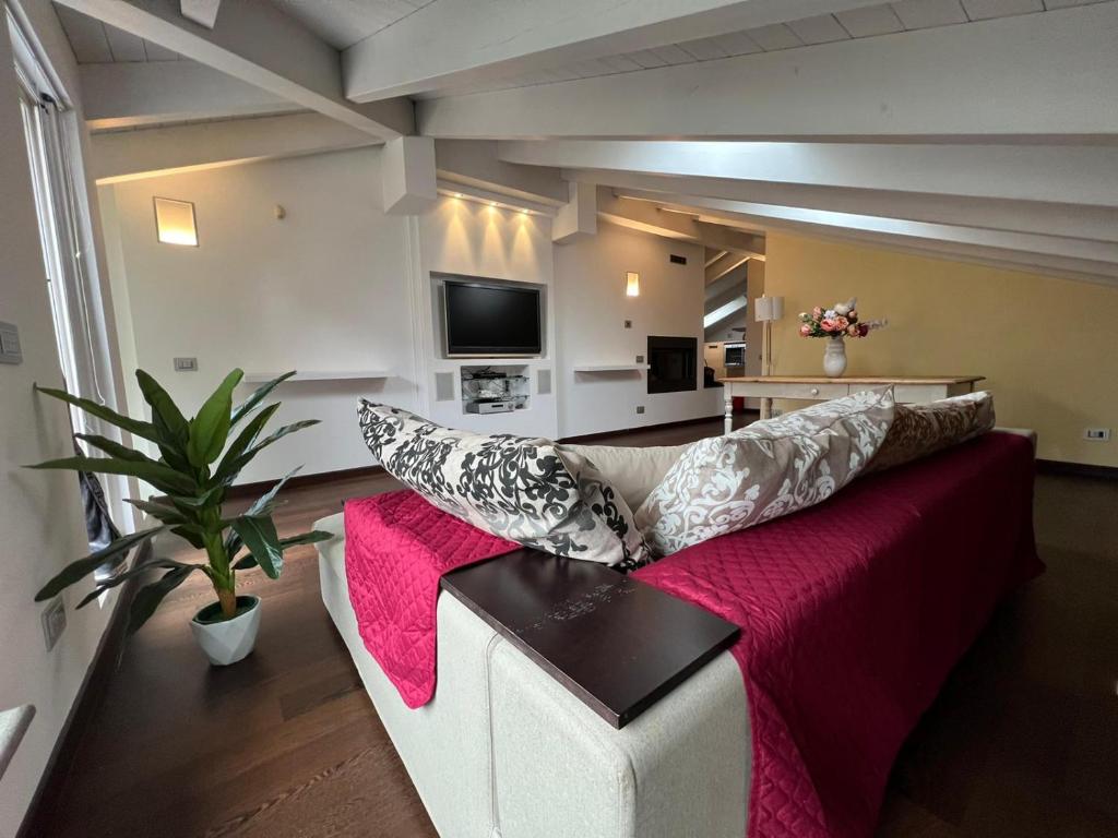 un soggiorno con divano rosso e bianco e cuscini di Appartamento incantevole a piacenza a Piacenza