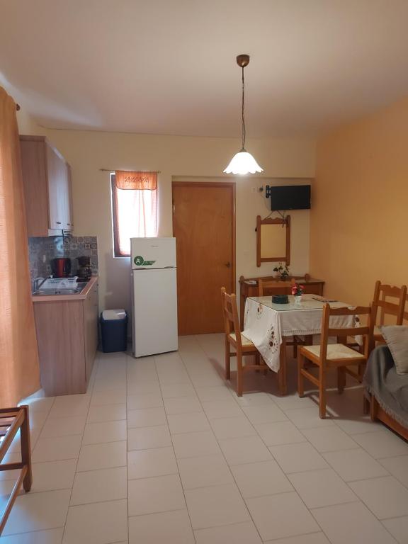 a kitchen with a table and a white refrigerator at Amaryllis Hotel in Karpathos