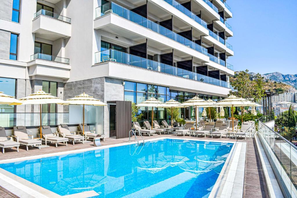 an image of a hotel pool with chairs and umbrellas at Katamare Hotel in Budva