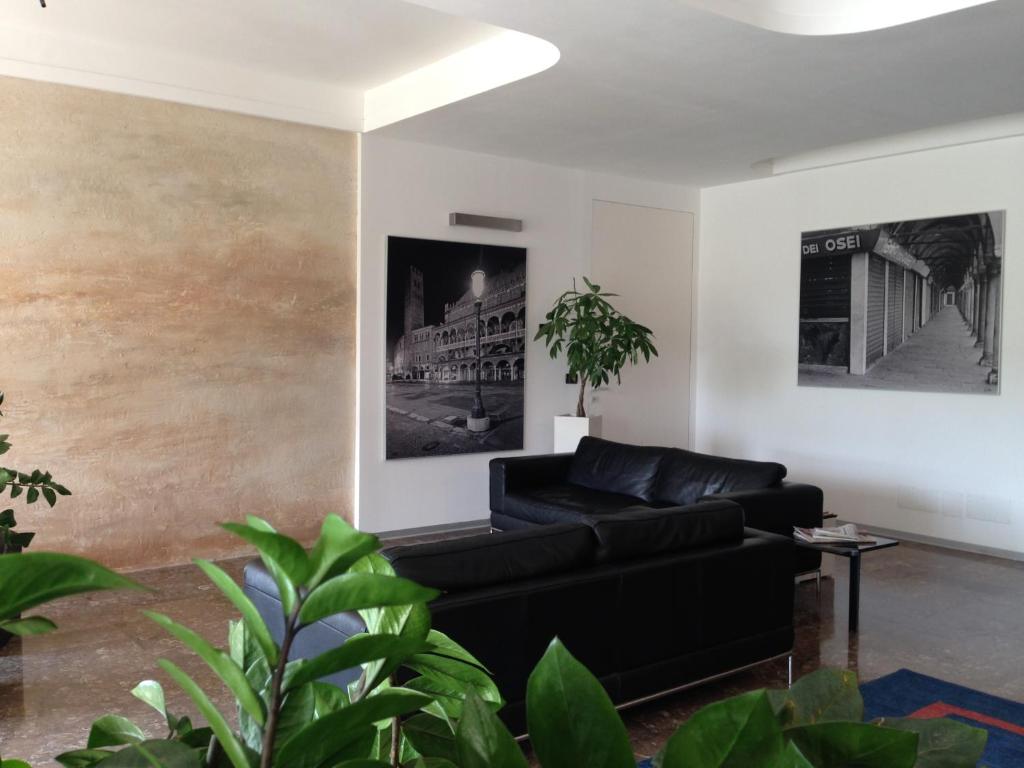 a living room with a black couch and a wall at Hotel Al Cason in Padova