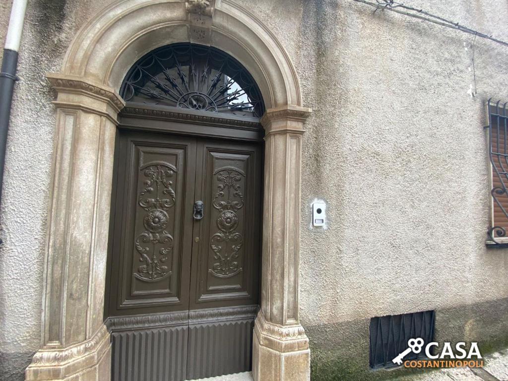 a large wooden door with an arched window on a building at Casa Costantinopoli in Padula