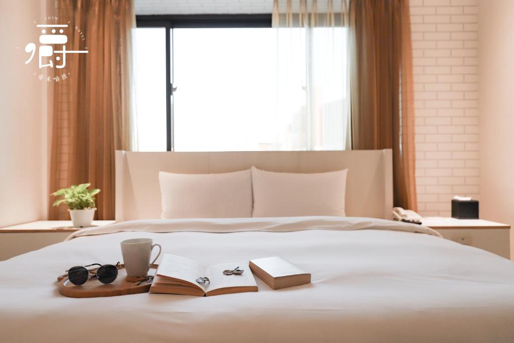 a bedroom with a bed with a book and glasses at Anho Chew Hotel in Luodong