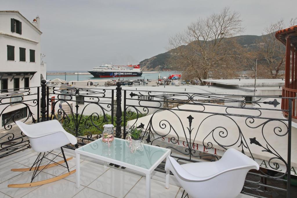 balkon ze szklanym stołem i 2 krzesłami w obiekcie Port view apartment w mieście Skopelos