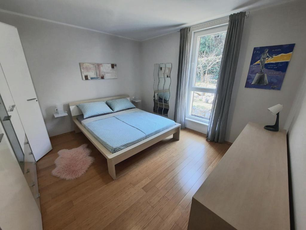 a bedroom with a bed with blue sheets and a window at MORABEZA Opatija in Opatija