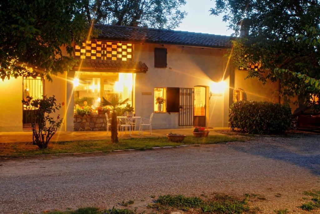 Una casa blanca con luces en la parte delantera. en Agriturismo IL BORGHETTO, en Crespellano