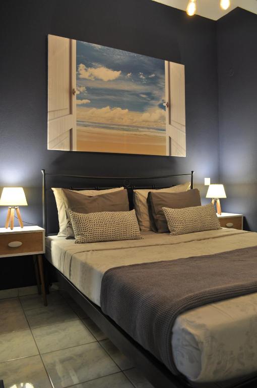 a bedroom with a large bed with a painting on the wall at Maro's Family Studios in Limenas