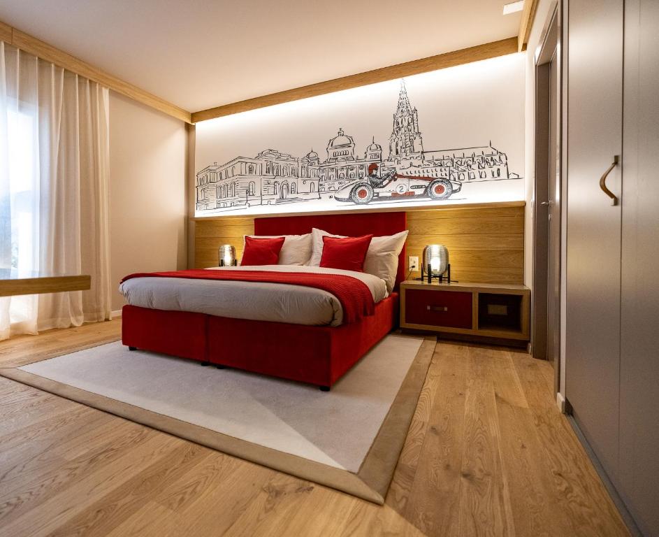 a bedroom with a red bed with a drawing on the wall at NEW OPENING 2022 - Los Lorentes Hotel Bern City in Bern