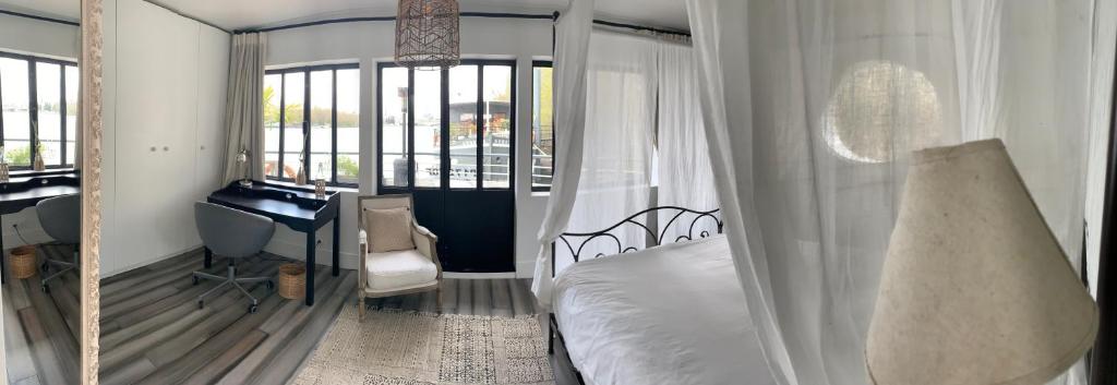 um quarto com uma cama, uma secretária e um espelho. em Loft sur l'eau avec parking em Paris