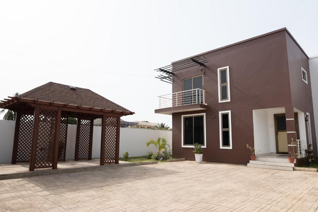 uma casa com um gazebo ao lado de um edifício em Baldwin Beauty House em Accra