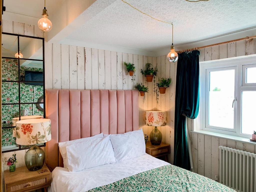 um quarto com uma cama e plantas na parede em The Townhouse 101 em Sandown