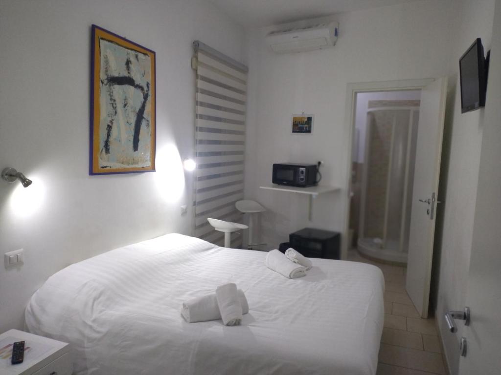 ローマにあるGuest House San Pietroのベッドルーム1室(白いベッド1台、タオル付)