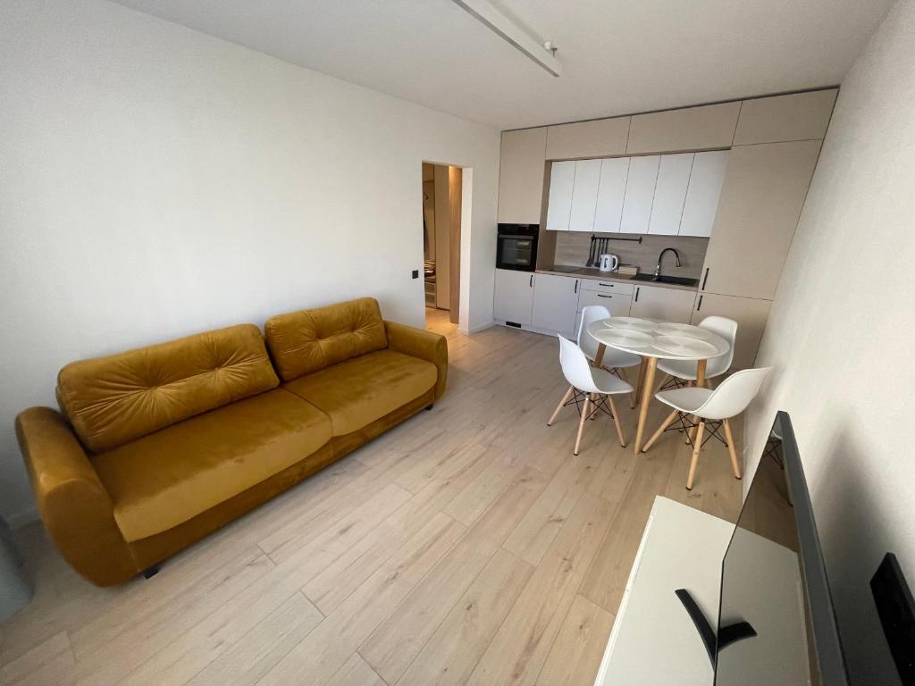 sala de estar con sofá y mesa en Livinga Lovely 1-bedroom apartment en Mažeikiai