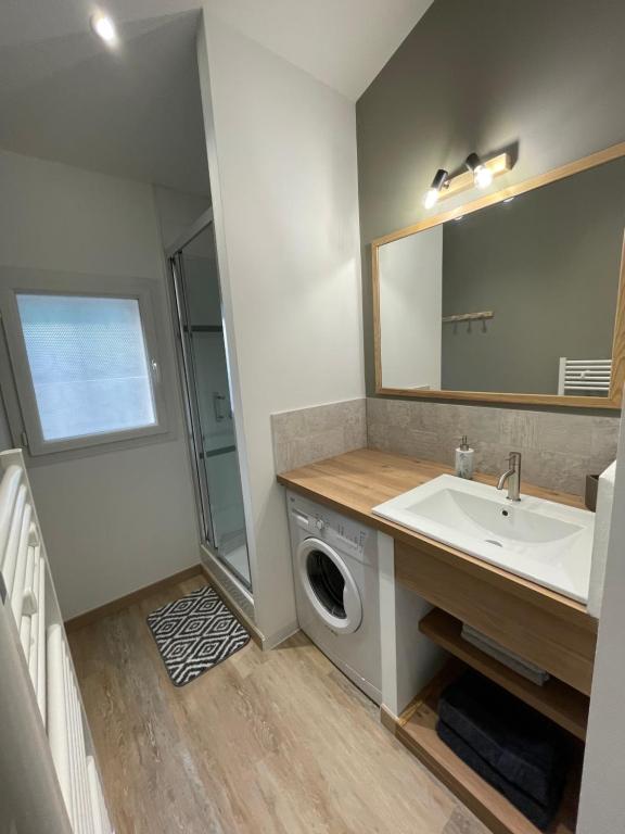 Un baño con lavabo y lavadora. en Le petit cassis, en Cassis