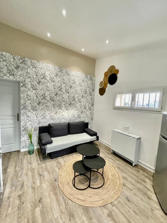 - un salon avec un canapé et deux tabourets dans l'établissement Le petit cassis, à Cassis