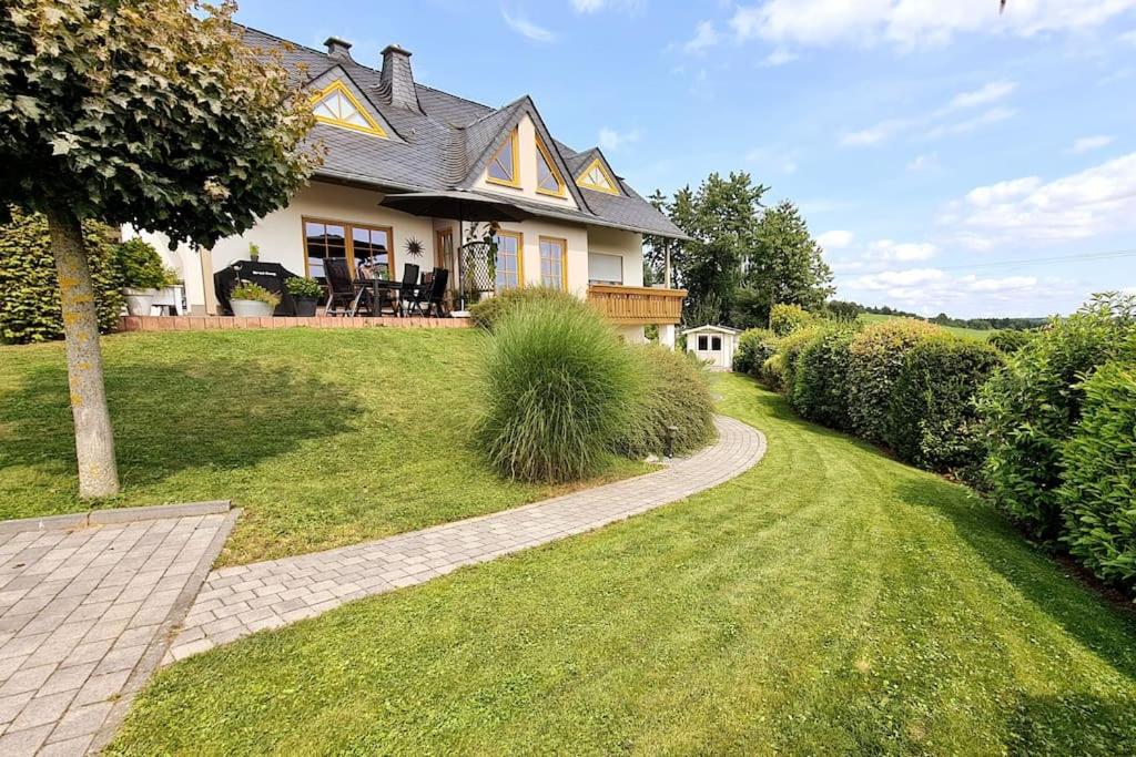 a house with a walkway in front of a yard at Ferienwohnung Moseltor in Monzelfeld