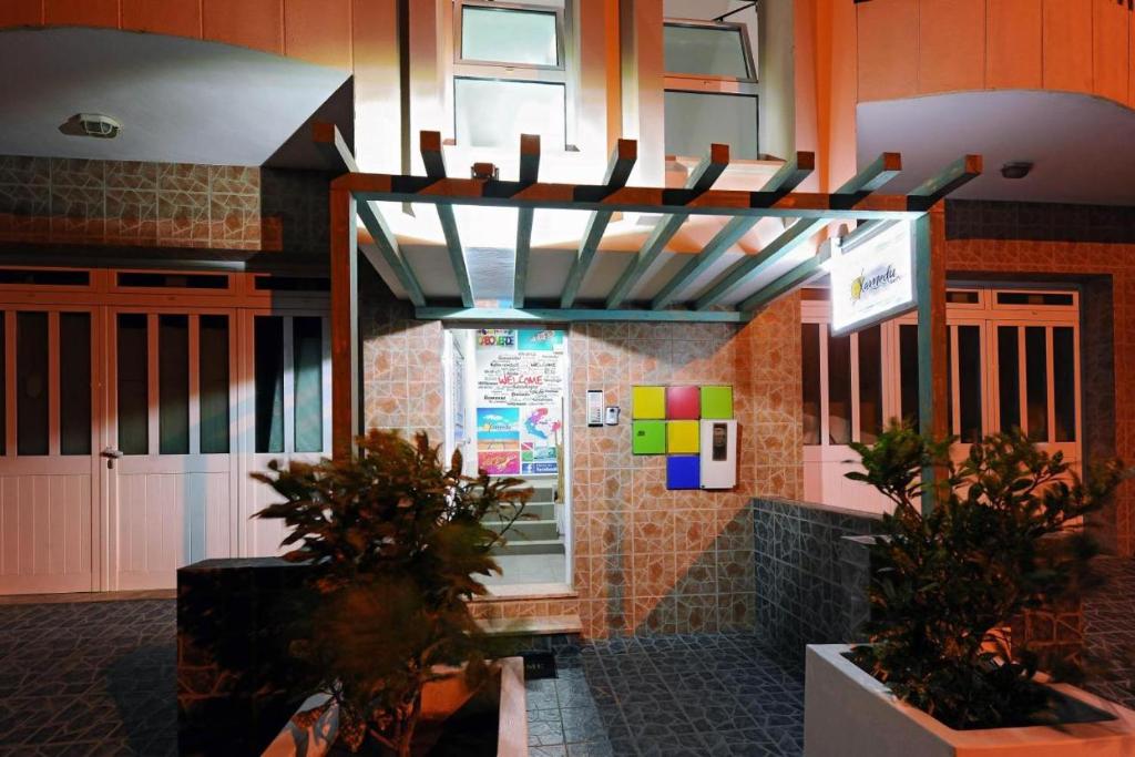 un restaurante con plantas frente a un edificio en AH Xamedu Sal Hostel en Santa María