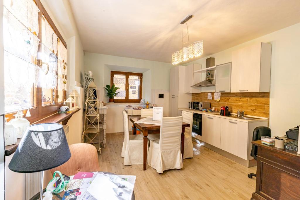 a kitchen with a table and a dining room at Locanda del sorriso b&b in San Quirico dʼOrcia