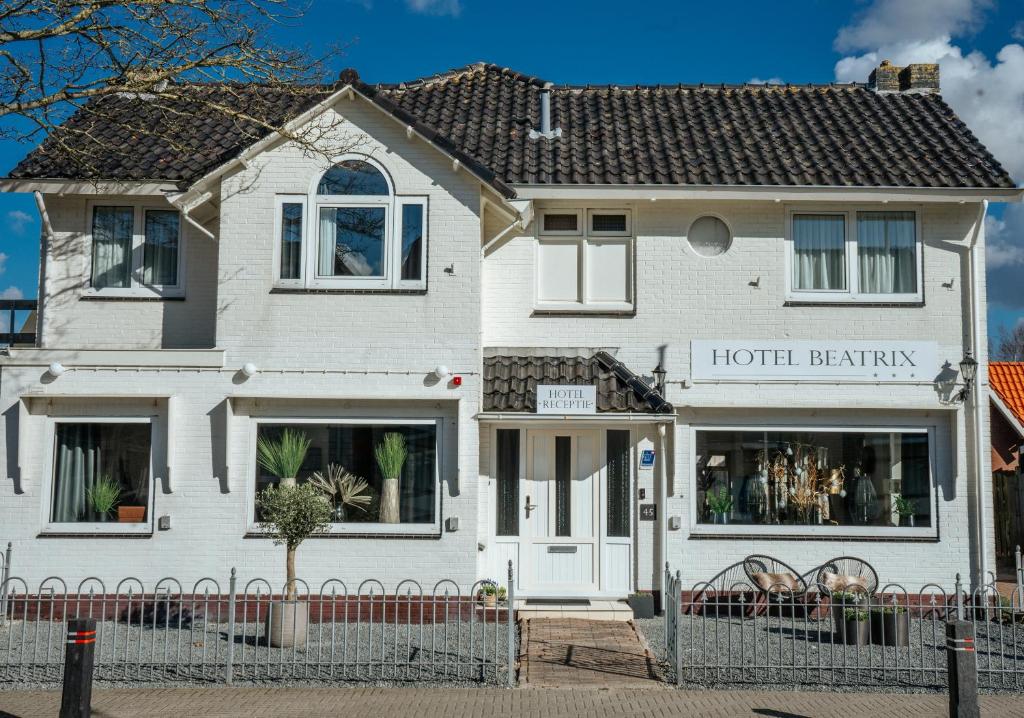 a white house with a hotel benefit sign on it at Hotel Beatrix in De Koog