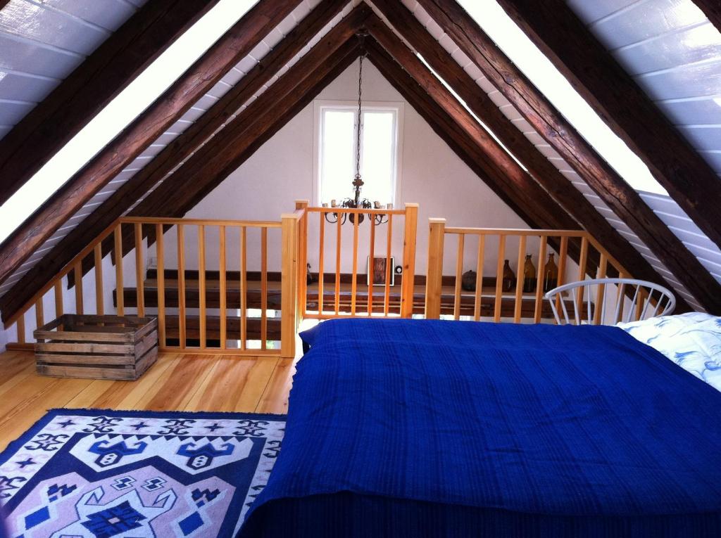 a bedroom with a blue bed in a attic at Hönshuset Kullabygden in Höganäs