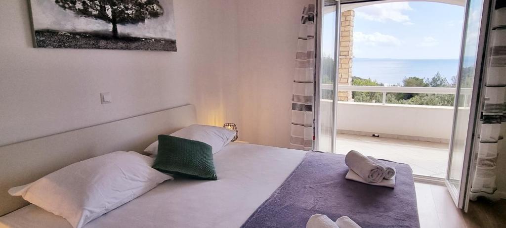 een slaapkamer met een bed en een groot raam bij Apartments Luma in Hvar