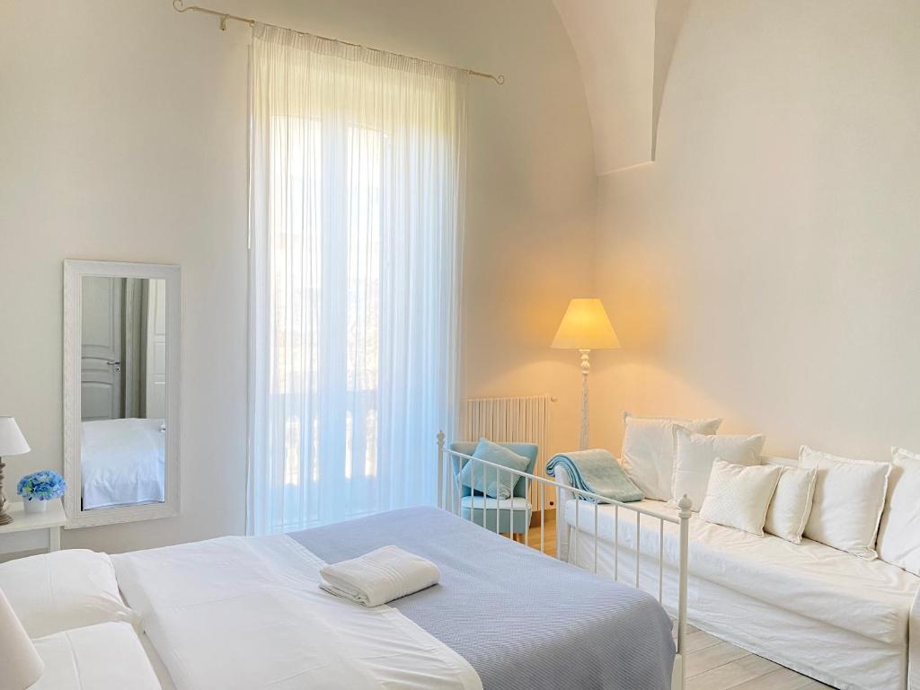 レッチェにあるAlla Luce del Baroccoの白いベッドルーム(ベッド1台、ソファ付)