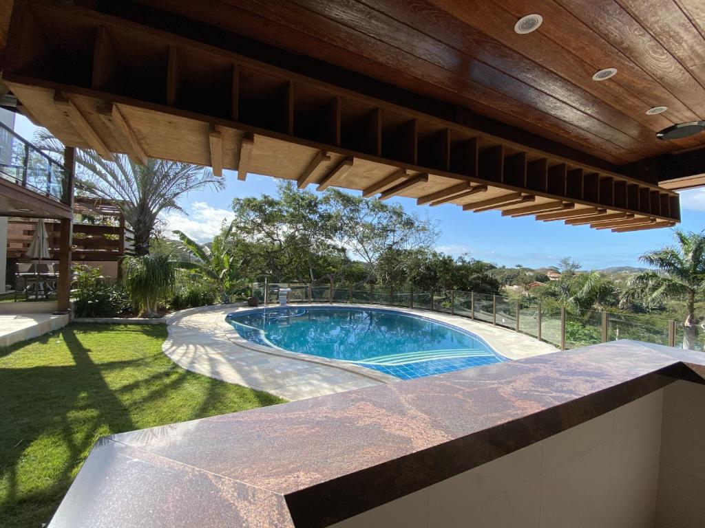 an outdoor patio with a swimming pool in a yard at Maravilhosa Casa Buzios in Búzios