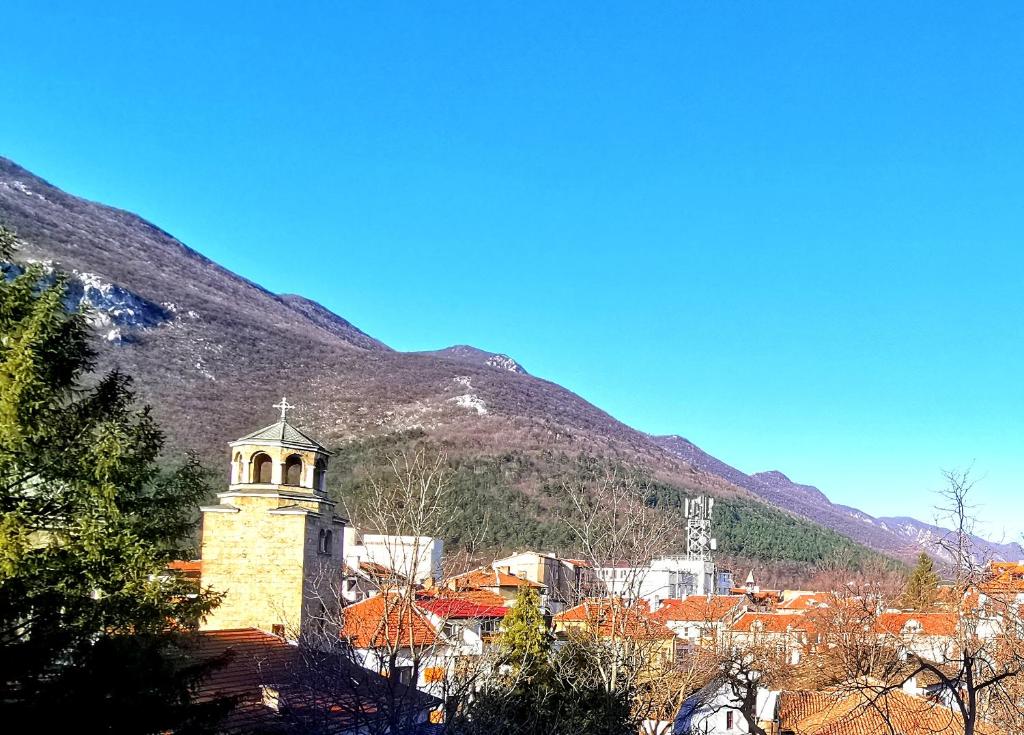 a town with a clock tower in front of a mountain at Balkan view apartment in Vratsa