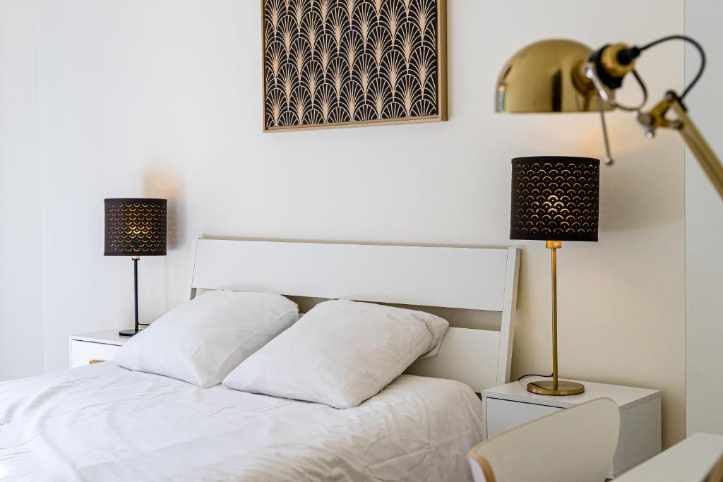 - une chambre avec un lit blanc et 2 lampes dans l'établissement Gare St Charles- Superbe appartement avec 3 chambres, à Marseille