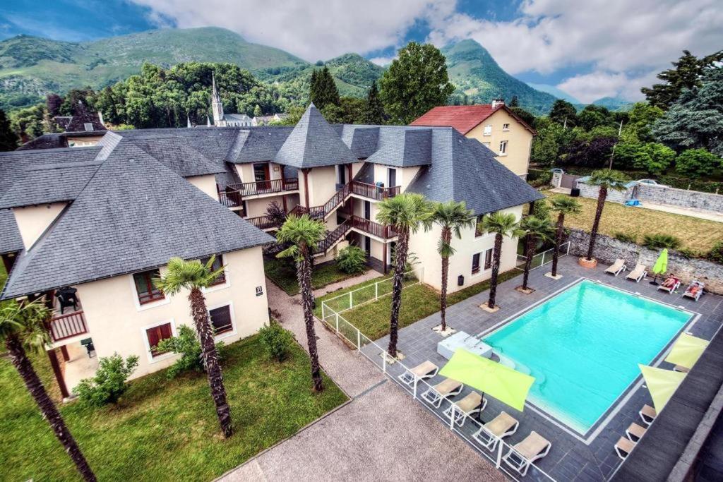 an aerial view of a house with a swimming pool and palm trees at Appartement de l'Isard Bleu, dans résidence de tourisme 3 étoiles in Lourdes