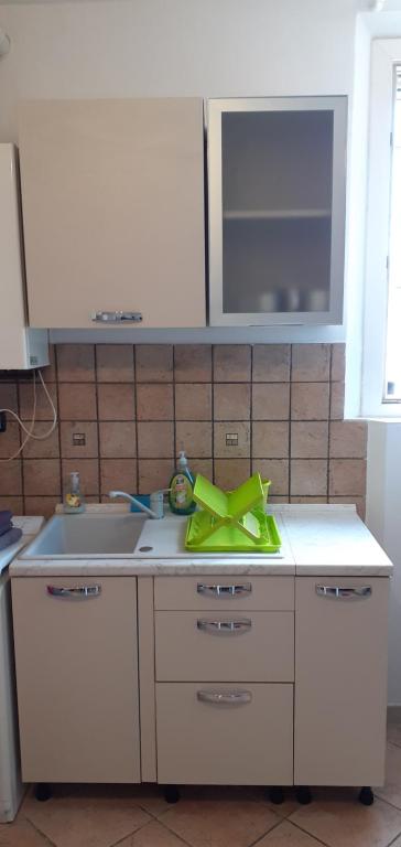 eine Küche mit einem Waschbecken und einem gelben Bogen auf der Theke in der Unterkunft Via Pioppa 24 in Ferrara