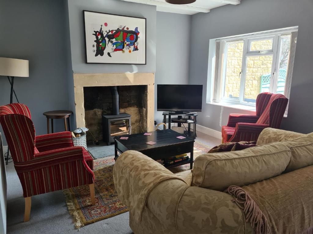 a living room with a couch and chairs and a fireplace at Number 8 Clandown in Radstock