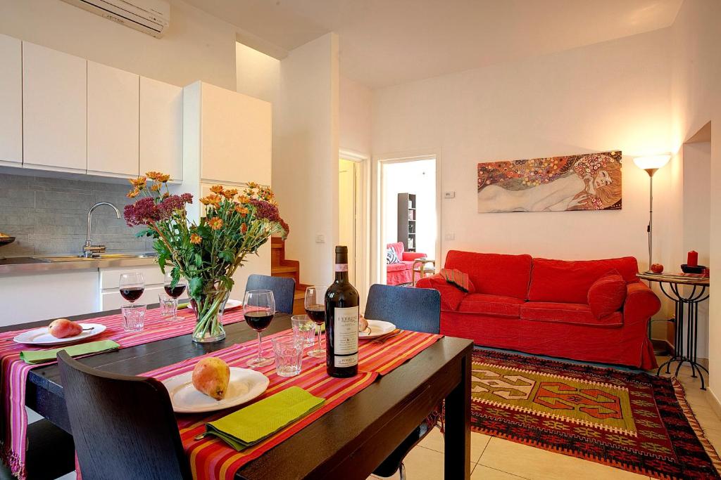 un soggiorno con tavolo e divano rosso di AnticaFirenze a Firenze