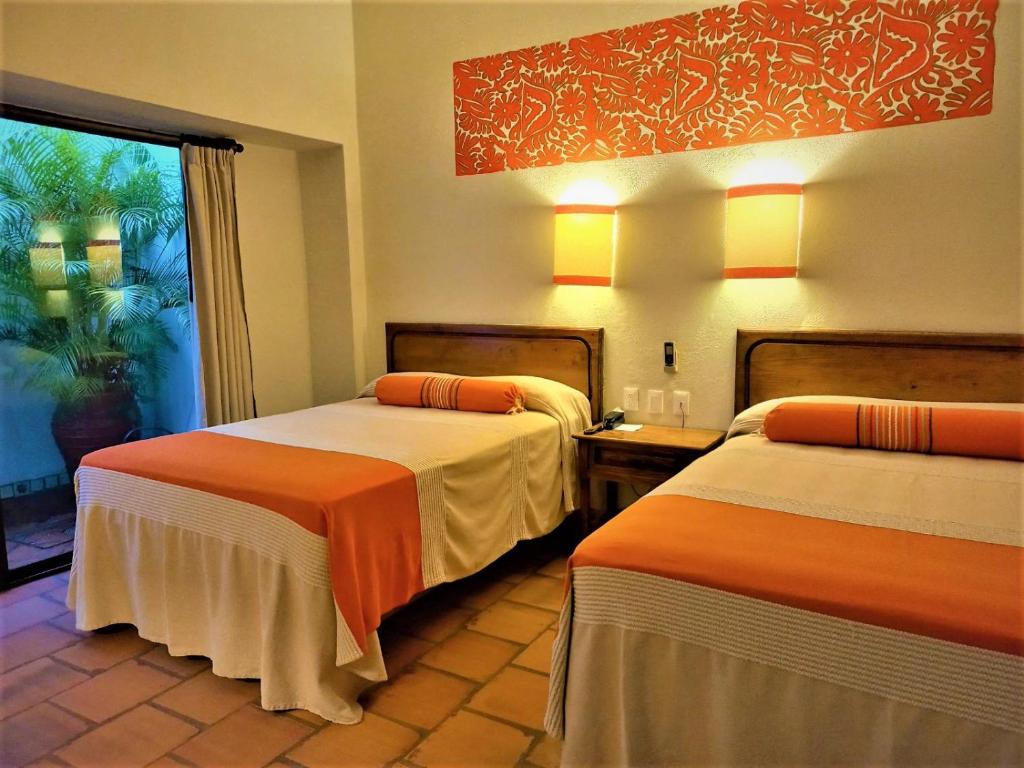 a hotel room with two beds and two lamps at Parador del Dominico in Oaxaca City