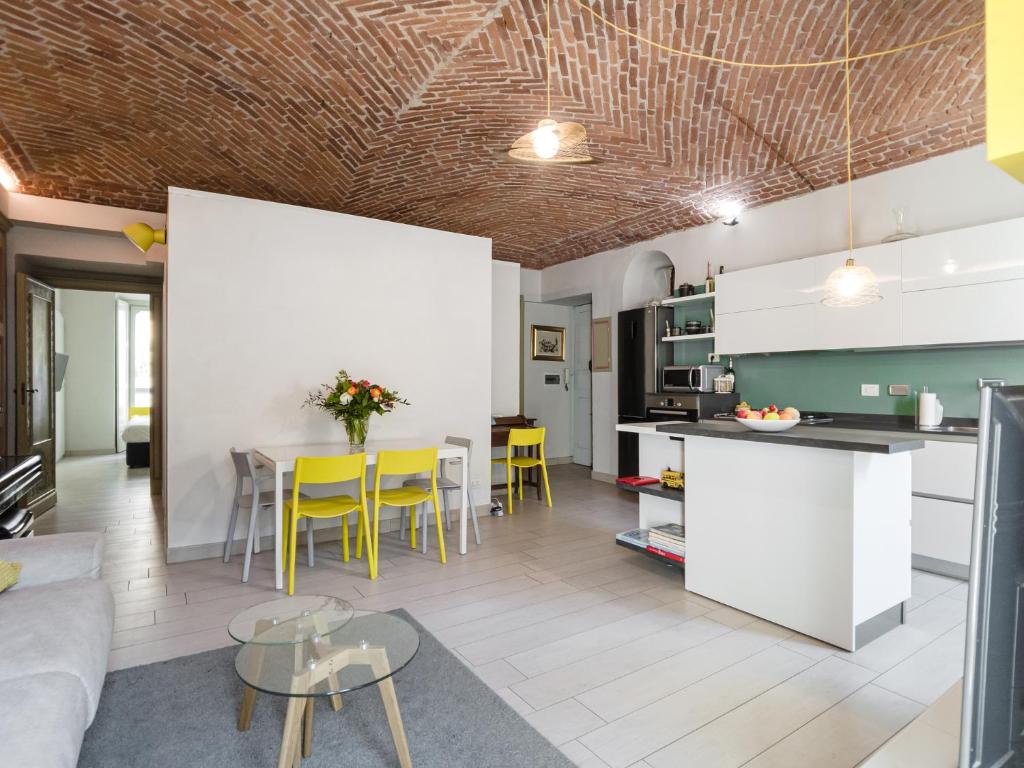 a kitchen and living room with a table and yellow chairs at Torino Centro Corso Matteotti in Turin