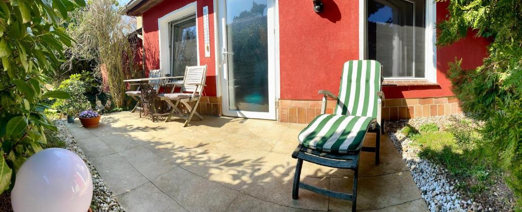 a patio with two chairs and a table in front of a house at HAUS MIT KUNST ZWISCHEN WALD UND SEE in Leipzig