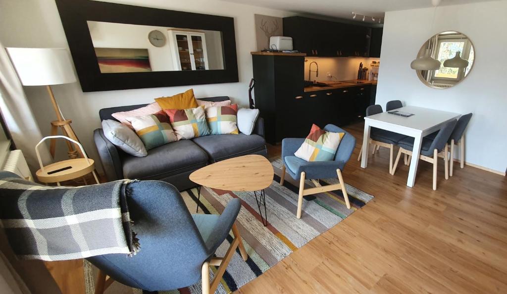 sala de estar con sofá, sillas y mesa en 2 pièces équipé avec parking privé, en Gryon
