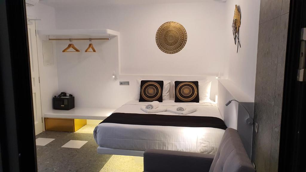 una camera con un letto con due cuscini sopra di Mykonos Double Luxury Mini Suites - Adults only ad Áno Merá