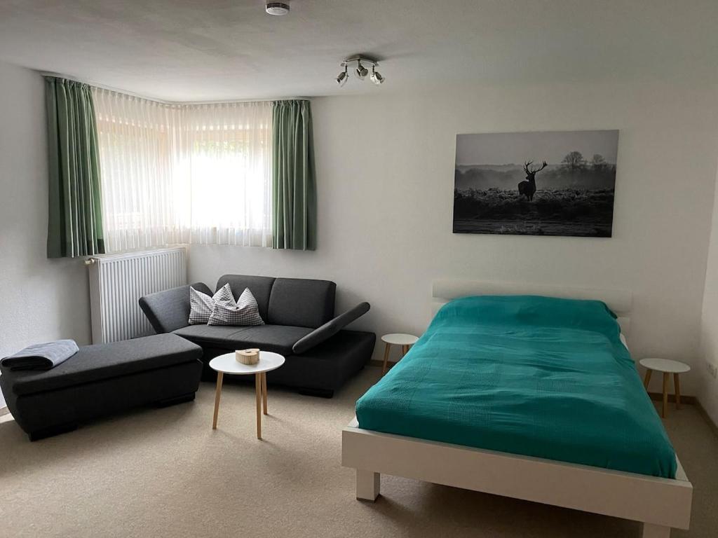 una camera con un letto verde e un divano di Appartement im Herzen des Allgäu‘s a Rettenberg