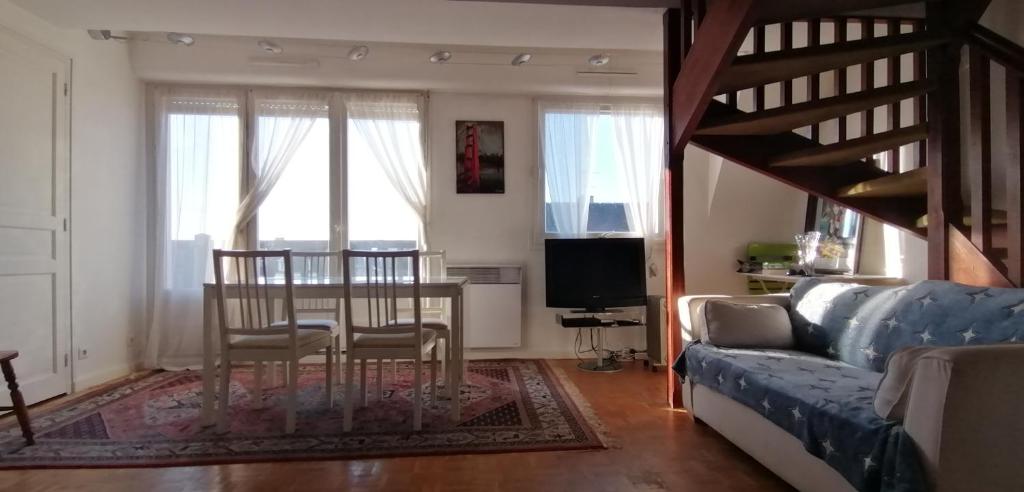 un salon avec un canapé et une table avec des chaises dans l'établissement 3 pièces Deauville Centre + wifi, à Deauville