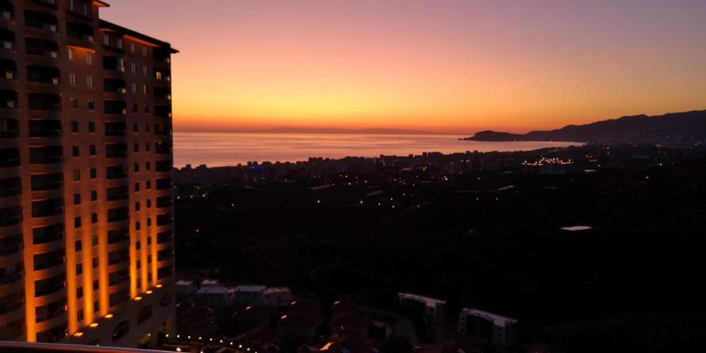 Blick auf eine Stadt bei Sonnenuntergang von einem Gebäude aus in der Unterkunft gold city alanya appartement in Kargıcak