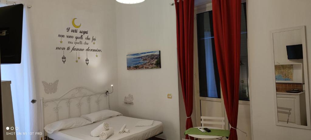 una piccola camera con letto e tenda rossa di Sweet Home a Napoli