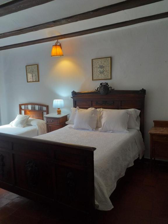 1 dormitorio con 2 camas y almohadas blancas en Fonda Del Tozal, en Teruel