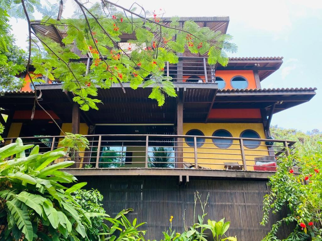 une maison avec un balcon sur le côté de celle-ci dans l'établissement Flamboyant Residence, à Fernando de Noronha