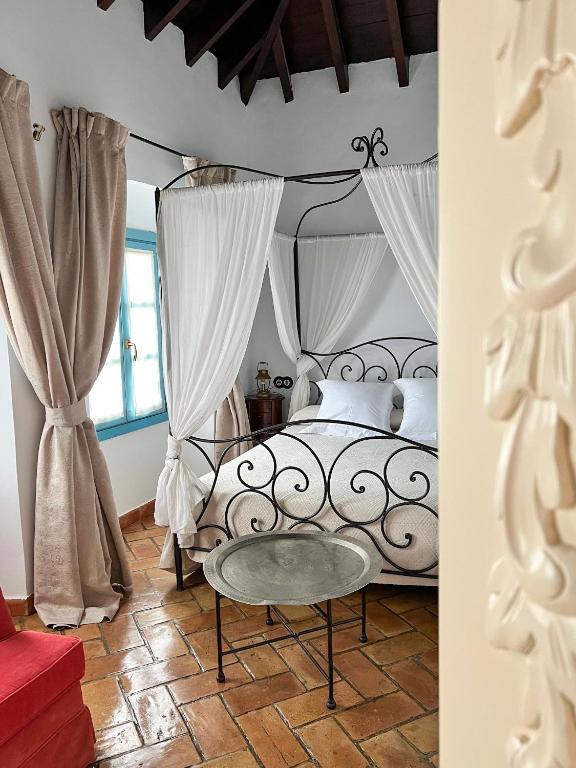 a bedroom with a black and white bed with curtains at Hotel Servilia in Carmona