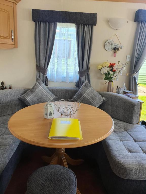 a living room with a table and a couch at The Topaz Caravan HF12 in Ingoldmells