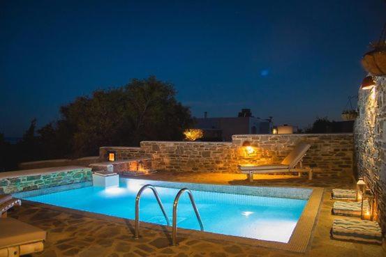 una piscina en un patio trasero por la noche en Crystal Villa 4, en Chrissi Akti
